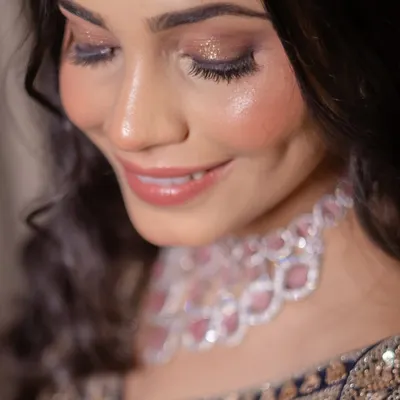 A close-up of a glamorous Sangeet makeup look. The focus is on the shimmery, smokey eye makeup and glossy nude lips, perfect for an evening of celebration.