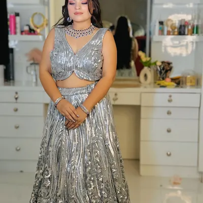 A full-length view of a dazzling silver sequin lehenga. The wave-like pattern of the sequins creates a fluid, glamorous look perfect for an engagement or cocktail night.