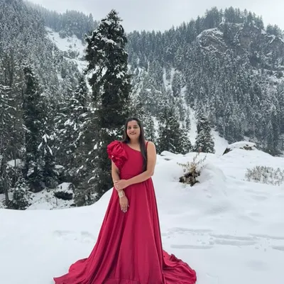 Make your pre-wedding shoot epic with one of our rental gowns. This vibrant red one-shoulder gown with a ruffled sleeve provides a stunning pop of color, especially in a scenic location like this snowy landscape.