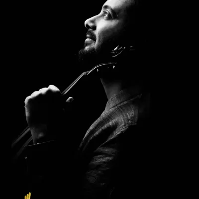 In our studio, we control every element of light and shadow to create powerful, artistic portraits. This dramatic black and white photograph of a musician with his violin uses a low-key lighting technique to sculpt his features and convey a deep sense of passion and introspection.