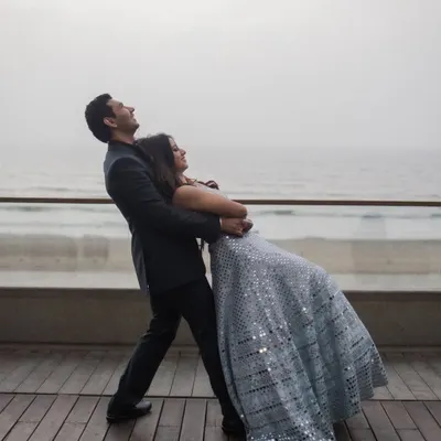 A moment of pure, carefree joy. This playful dip on a seaside deck captures the fun and spontaneity we love to encourage in our shoots. It's all about having a great time together.