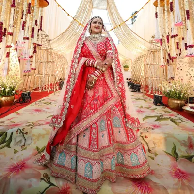 A full view of this breathtaking Rajasthani bride. Her makeup was designed to be flawless from every angle, with classic red lips and defined eyes that stood out against her elaborate red bridal lehenga.