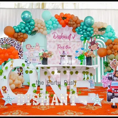 A full view of Dishant's "Wild One" birthday, showcasing a vibrant mix of animal prints, character cutouts, and a colorful balloon arch. This setup combines playful elements like a giraffe and zebra with a custom "ONE" table for a complete jungle safari look.
