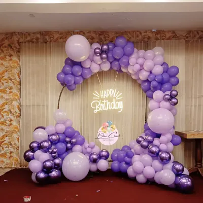 A beautiful organic balloon garland on a ring frame in shades of purple, perfect for a birthday party.