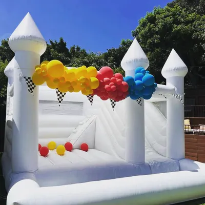 Our elegant white bouncy castle, shown here with a slide and ball pit, is a versatile choice for any event, from birthdays to more formal gatherings. It can be decorated with balloons to match your party's theme.