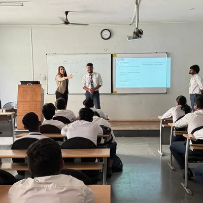 Here, I'm guiding a student through a presentation exercise in front of the class. Building confidence comes from doing, and these practical sessions are key to overcoming public speaking anxiety.