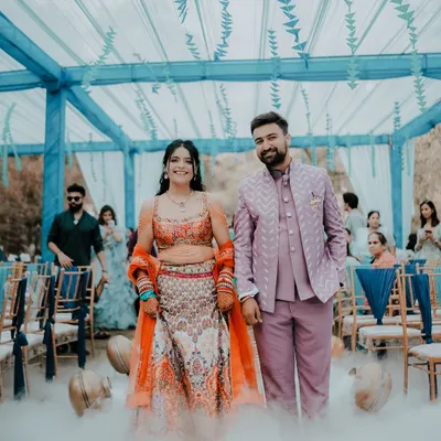 I captured Ankita and Rajat making their grand entrance at their Mehendi in Dehradun. The dreamy smoke effect and the vibrant blue and orange decor created a truly cinematic moment, just like a movie scene.