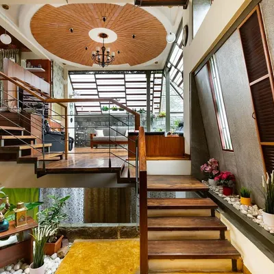 This perspective highlights the home's verticality and our use of mixed materials. The wooden staircase, exposed concrete, and a circular brick ceiling detail work together to create a rich, textured interior with views across different living zones.