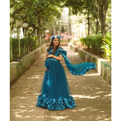 Let the gown do the talking. This full length shot in a park walkway shows how a dramatic tulle gown with a long train can create breathtaking, memorable maternity portraits. The vibrant color stands out beautifully against the natural greenery.