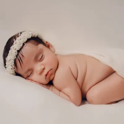 The classic newborn pose. This simple, beautiful portrait focuses on the baby's peaceful expression and tiny features, wrapped gently in a soft cloth. It's a timeless way to remember how small they once were.