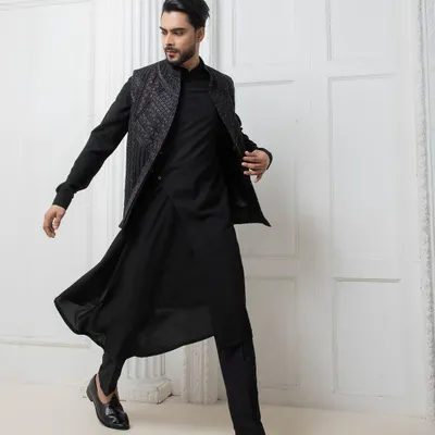 I design for movement and impact. This black Indo-western set features a hand embroidered jacket over a fluid, draped kurta, offering a modern and dynamic option for a sangeet or reception.