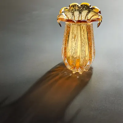 Where light dances on glass. This hand-blown amber glass vase is designed to catch the light, casting beautiful shadows and becoming an art piece in its own right.