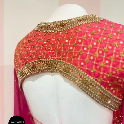This backless, full-sleeve blouse features an elaborately embroidered panel, creating a look that is both dramatic and elegant.