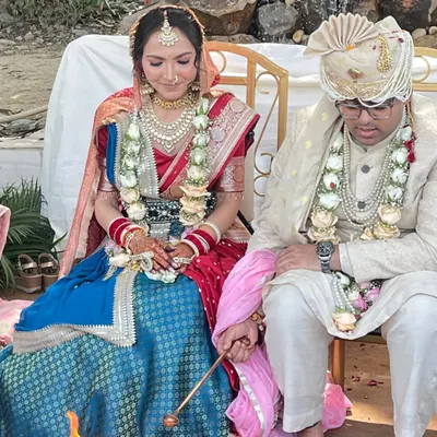 A beautiful moment from a client's wedding ceremony. She is wearing a custom-designed Tehhzeeb bridal lehenga, combining a blue brocade skirt with a traditional red dupatta for a timeless look.