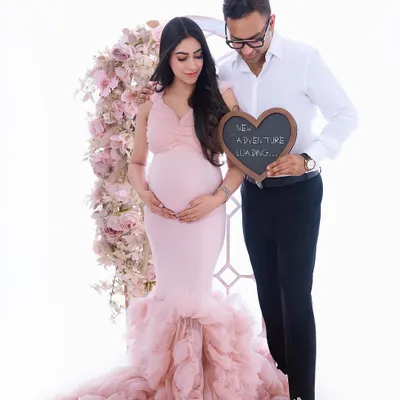 A sweet announcement for your next chapter. This couple's portrait uses a fun prop and a beautiful floral arch to celebrate the adventure ahead, all wrapped in a soft, romantic aesthetic.
