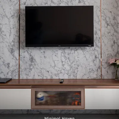 This minimalist TV unit combines a luxurious marble-finish backdrop with warm wood and elegant fluted glass. It's a perfect example of how we blend textures to create a clean, sophisticated look while providing ample storage.