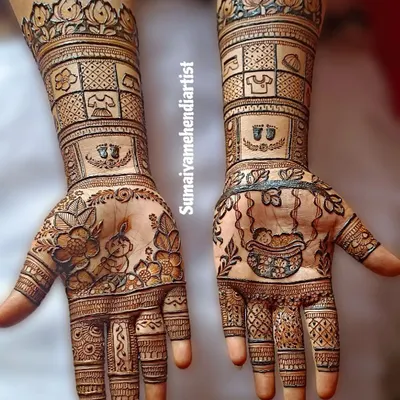 A full view of a beautiful baby shower henna design, with a baby in a cradle on one hand and other cute motifs.