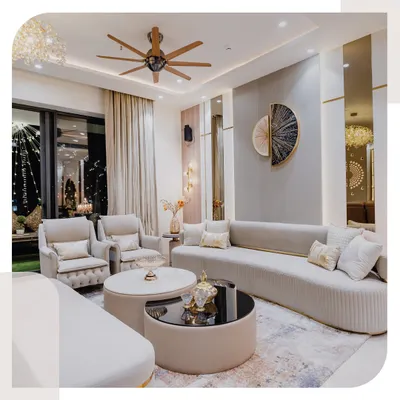 This living room is all about creating a feeling of warmth and elegance. The curved sofas soften the space, while the gold accents and layered coffee tables add a touch of modern luxury. The large windows and sheer curtains ensure the room is always filled with natural light.