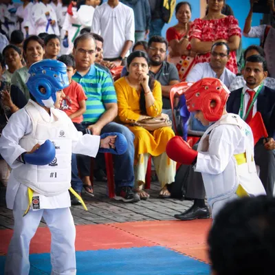 Young competitors engage in a Kumite match while parents and spectators watch. Our championships are family-friendly events that celebrate the hard work and courage of every participant.