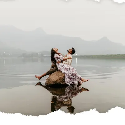 An epic shot of the couple relaxing on a rock in the middle of a serene lake, with the mountains of the ghats in the background.
