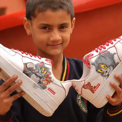 Sometimes the best photoshoots are the ones you don't plan. This kid's smile says it all. Here he is holding the Tom and Jerry themed Nike Air Force 1 Supremes I painted.