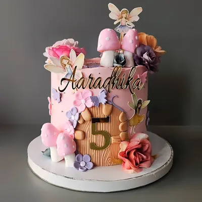 A magical fairy theme cake for Aaradhika's 5th birthday. This butterscotch cake features a fairy house with mushroom details, delicate wings, and whimsical flowers.