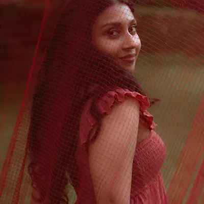 A beautiful portrait of Deyana, with a soft, knowing glance. This shot, taken through a red veil, has a dreamy and intimate quality.