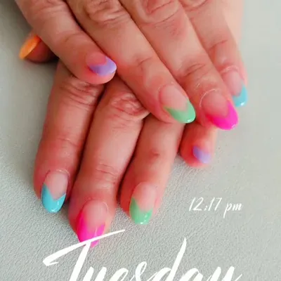 A close-up of the multi-color French tip design, showing the blend of neon and pastel shades on each nail.