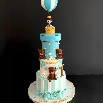 A grand celebration for a first birthday! This four-tiered cake for Avyaan features adorable teddy bears, a starry sky, and a little prince in a hot air balloon topper.