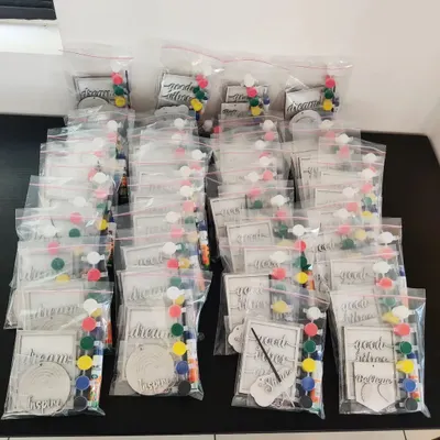 Here is a large batch of custom DIY art kits being packed as return gifts for a birthday. Each bag contains everything needed for a fun art project, making it a memorable party favor.