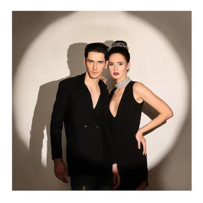 A glamorous power couple portrait, with both models dressed in black and posing in a dramatic spotlight. This showcases my ability to create high-fashion, editorial-style images for two.