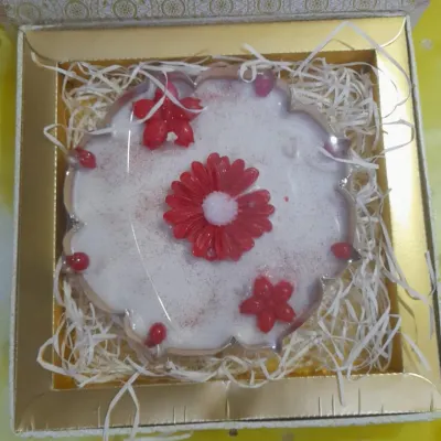 Make this Diwali unforgettable with a stunning urli at the heart of your rangoli. This one features a large red flower candle surrounded by smaller ones, all nestled in a beautiful gift box.