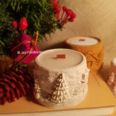 Our 'Winter Lights' Jar Candle, featuring a cozy, textured winter cabin scene. We make the jar from Jesmonite and fill it with 100% soy wax, creating a piece that brings warmth and a season in a flame.