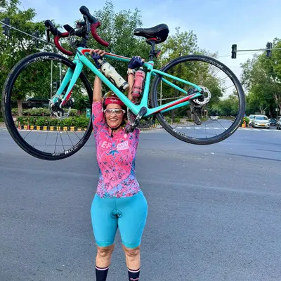 The pure joy and strength of cycling. One of our members celebrating a great ride by lifting her bike in triumph.