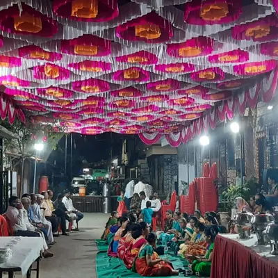 A large gathering seated on the floor inside a pandal. I provide carpets (galicha) and manage the complete seating arrangement for community dining or functions.