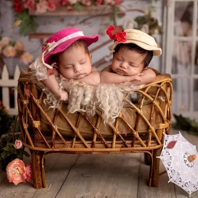 When a mom requested a Bridgerton theme for her twins, I was so excited! Look at these two little debutantes with their tiny hats, sleeping in a vintage-style bassinet surrounded by flowers.