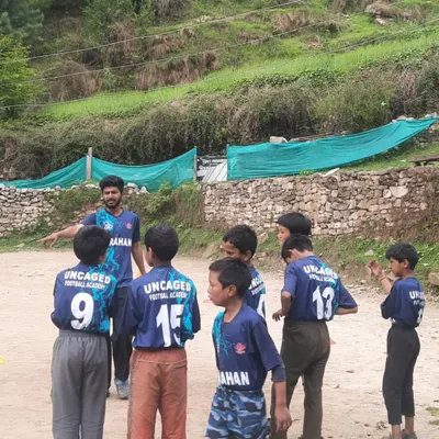 A typical coaching moment on the field in Grahan. I'm explaining a drill to the newly-formed team, all looking sharp in their Uncaged Football jerseys. Clear communication and focus are key to our training sessions.