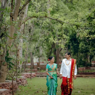 A candid shot of the couple taking a stroll through a lush park after their wedding. This natural, unposed moment captures their easy comfort with each other.