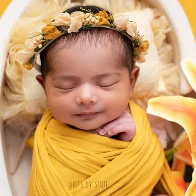 A sleepy smile from a sweet newborn. This is why I do what I do. These moments are so fleeting, and I feel honored to preserve them for you. This portrait was created using a soft yellow wrap and a delicate floral headband for a touch of sunshine.