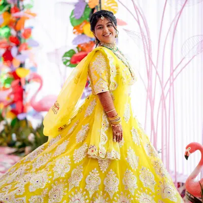 A radiant bride-to-be at her colorful Mayra celebration. Her bright yellow lehenga and joyful smile perfectly capture the spirit of this fun-filled pre-wedding event.
