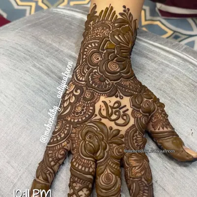 A beautiful, intricate design featuring a client's name elegantly written in Arabic script on the palm.