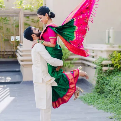 A playful and dynamic shot of Amit lifting his fiancée Asawari during their outdoor engagement shoot. Her green and pink saree adds a beautiful pop of color.