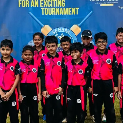 The Under-10 team, featuring both boys and girls, poses proudly in front of the Canara Bank Premier League banner during the RSCA Dasara Cup.