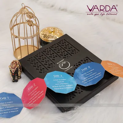 This image displays the detailed itinerary inserts for a multi-day corporate event. Each uniquely shaped card outlines the schedule for a specific day, fitting perfectly within a custom laser-cut box to keep guests informed in style.