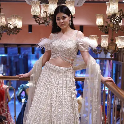 Drape yourself in opulence with this gold and white lehenga, featuring stunning feather sleeve detailing. It’s a masterpiece for the modern queen seeking a touch of glamour.