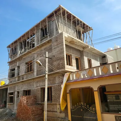 The brickwork and structural frame of a multi-story bungalow under construction. This image shows the project taking shape according to our architectural plans.