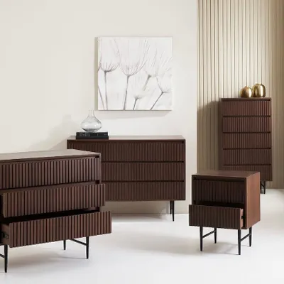A group shot of the 'Slatted Collection' for a UK brand. This image effectively displays the range of pieces available, including chests of drawers and a nightstand, in a clean, contemporary setting.