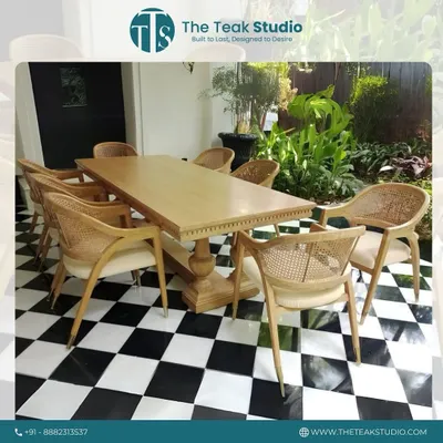 This beautiful eight-seater dining set was crafted for a farmhouse. The solid teak wood table with its classic pedestal base is paired with elegant chairs that feature natural rattan backs, creating a bright and welcoming outdoor dining feel.