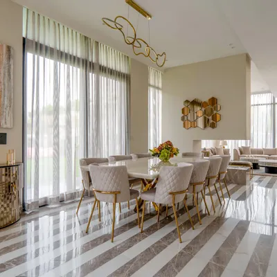 This peaceful dining area in a Chattarpur farmhouse is where minimalism and warmth create the perfect recipe. The striped Italian marble floor, beige and grey palette, and a touch of gold create a tranquil yet stylish atmosphere.