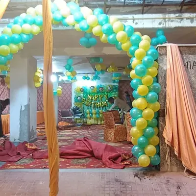 This large balloon arch was created for a birthday party in a banquet hall. The bright yellow and teal colors create a fun and vibrant entrance, setting the tone for the celebration inside. We can build arches of any size to fit your space.